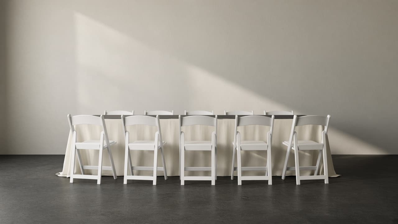 Representative photo of an empty banquet table and white folding chairs, set and ready.